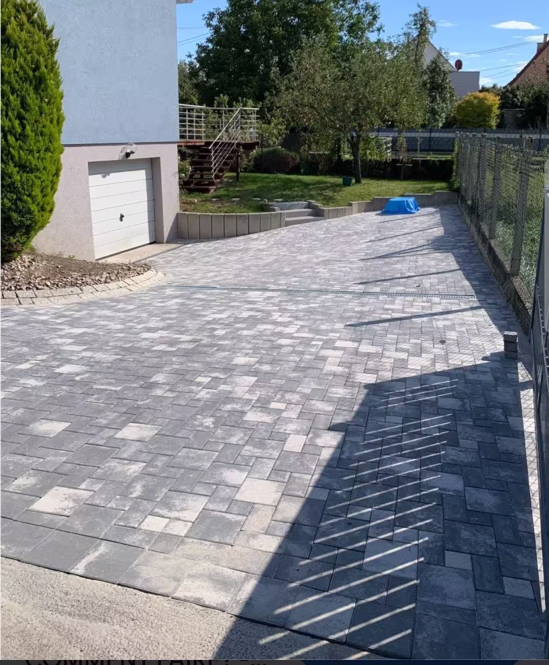 Allée pavée en cours de finition devant un garage